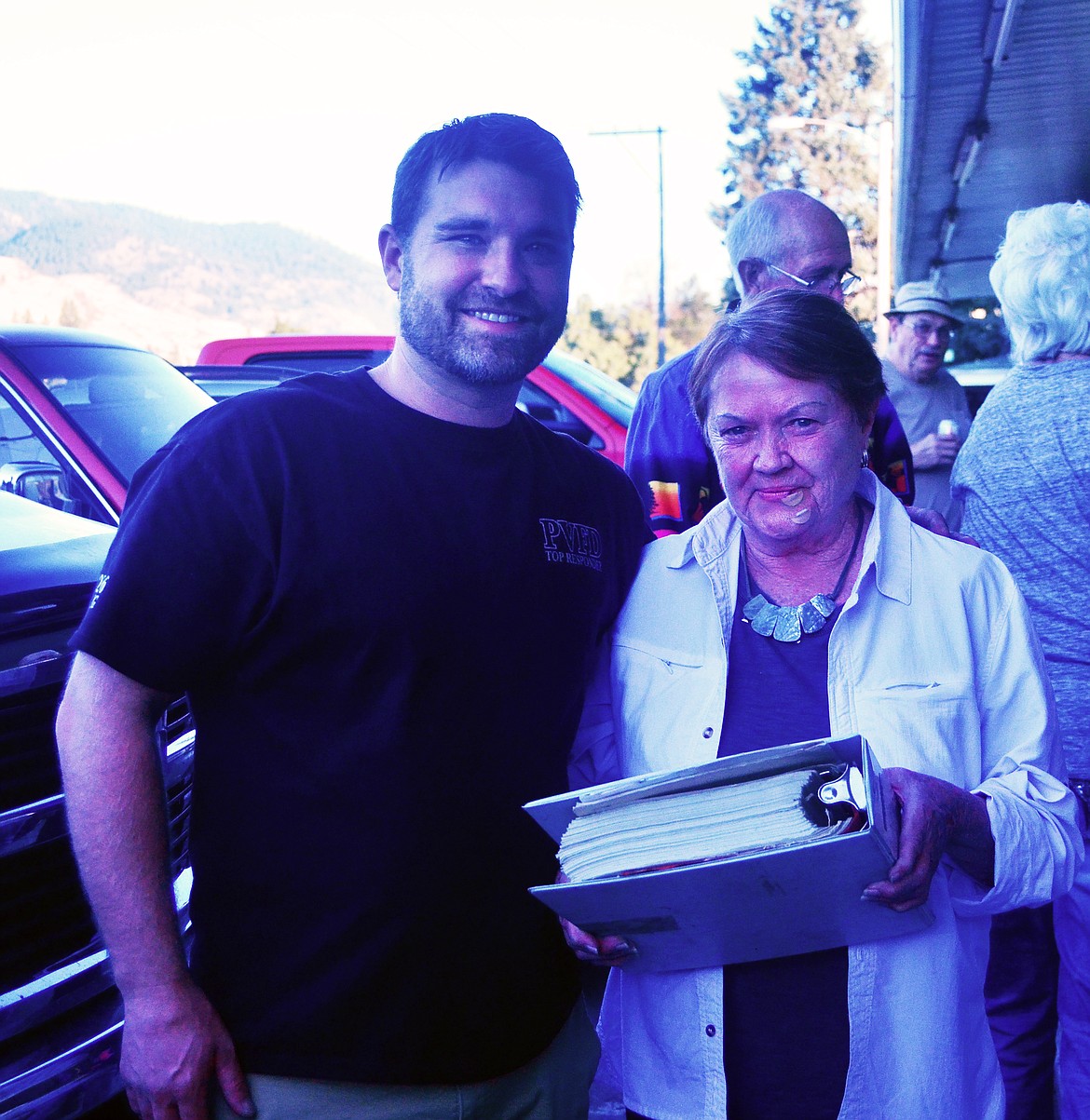 Fire Chief Anthony Young with Patsy Wagoner as he hands over the title of the vintage truck. (Erin Jusseaume/ Clark Fork Valley Press)