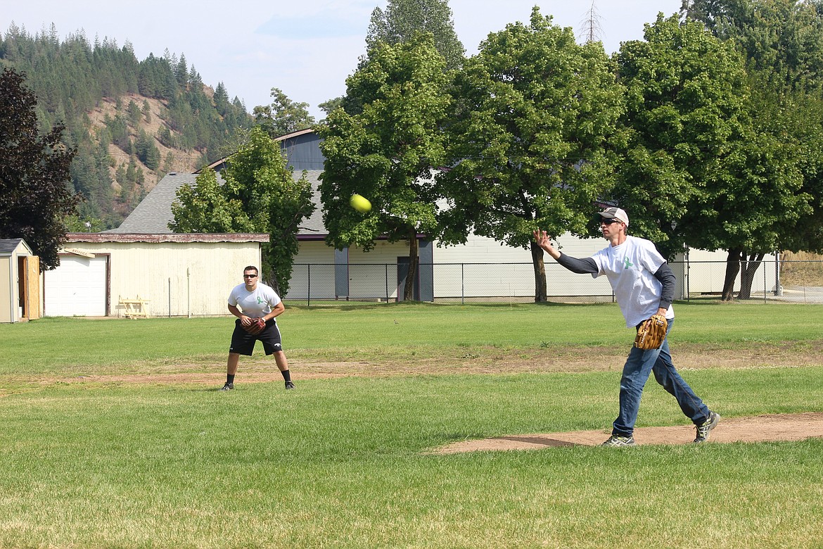 SCFD1 Fire Chief Aaron Cagle sends out a pitch while fire fighter Victor Malsom keeps his eye on the batter.