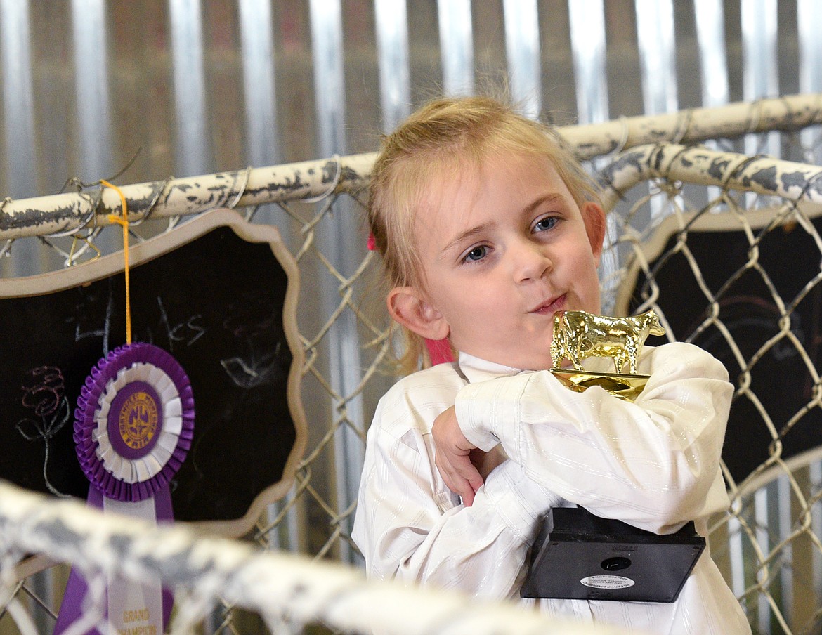 Lisa Tuck shows off her trophy after showing her dairy cow Sweetie at the Northwest Montana Fair on Wednesday. (Aaric Bryan/Daily Inter Lake)