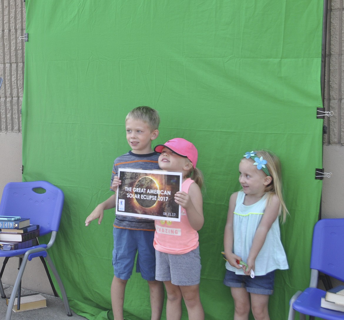 Pictured left to right are Owen Godfrey, 5, Quinn Godfrey, 3, and Olivia Johnson, 3, all of Polson. The kids posed for a photo outside of the library in Polson Monday during the solar eclipse.