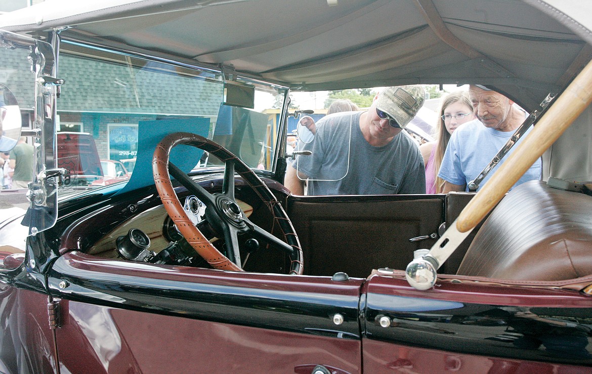 Ron Moon, left, Nicole Moon and Perry Harris study the interior of Mel Burnett&#146;s 1930 Model A Ford Saturday during Ignite the Nites 2017. (Paul Sievers/The Western News)