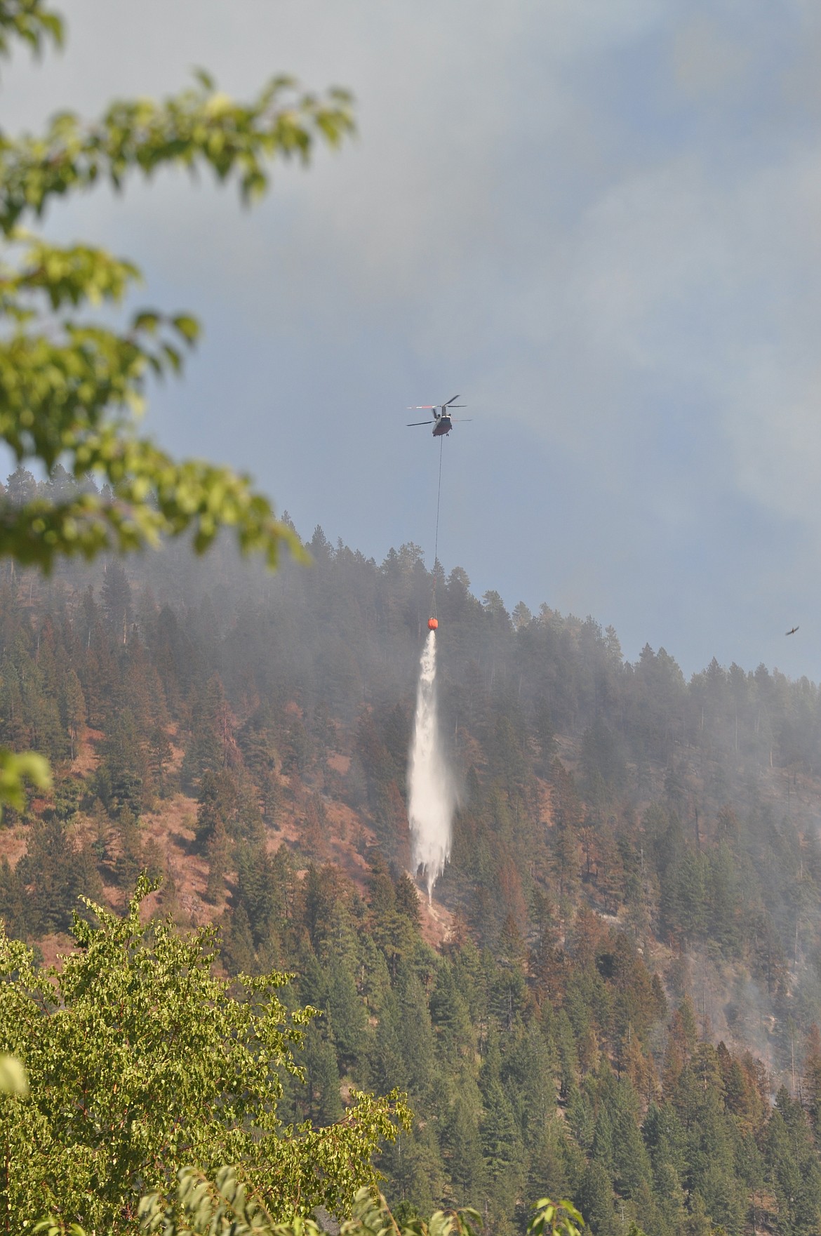 A type 1 helicopter battles the fire near Blue Bay Wednesday. (Photo by Chris Kelly)