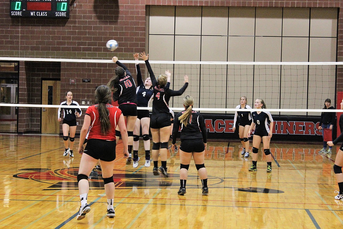 Multiple players jump for a loose ball above the net.