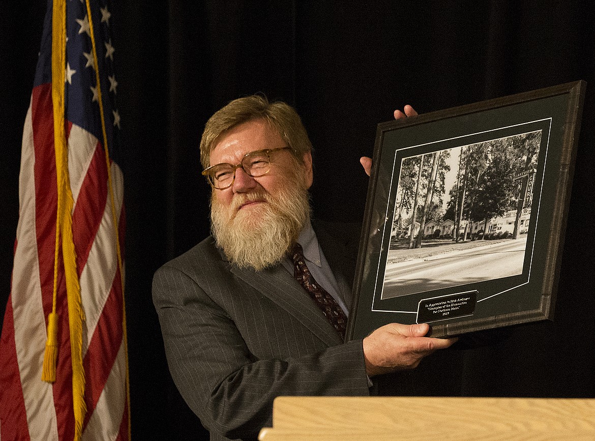 LOREN BENOIT/PressIdaho Humanities Council Executive Director Rick Ardinger smiles as he holds an award at the Idaho Humanities Council's 14th Annual North Idaho Distinguished Humanities Lecture Thursday night at The Coeur d'Alene Resort. Ardinger will step away from the IHC after 26 years to make way for a new director.