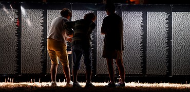 Sisters Beverly Young, of Gallipolice, Ohio, left, and Sue Williamson, of Blue Rock, Ohio, stand around their mother, Jean Johnson of Marion, Indiana, on Wednesday night at The Wall that Heals in Kalispell. The trio stopped in Whitefish on Wednesday while taking an America by Rail tour they started in Chicago. When they heard the Vietnam Memorial replica had arrived in Kalispell they decided to come see it and pay their respects. Sunday there will be two ceremonies at the wall, the opening ceremony at 10 a.m. and the closing ceremony at 4 p.m. The closing ceremony will feature a performance of Echo Taps by BJ Lupton and Gerry Schultz.