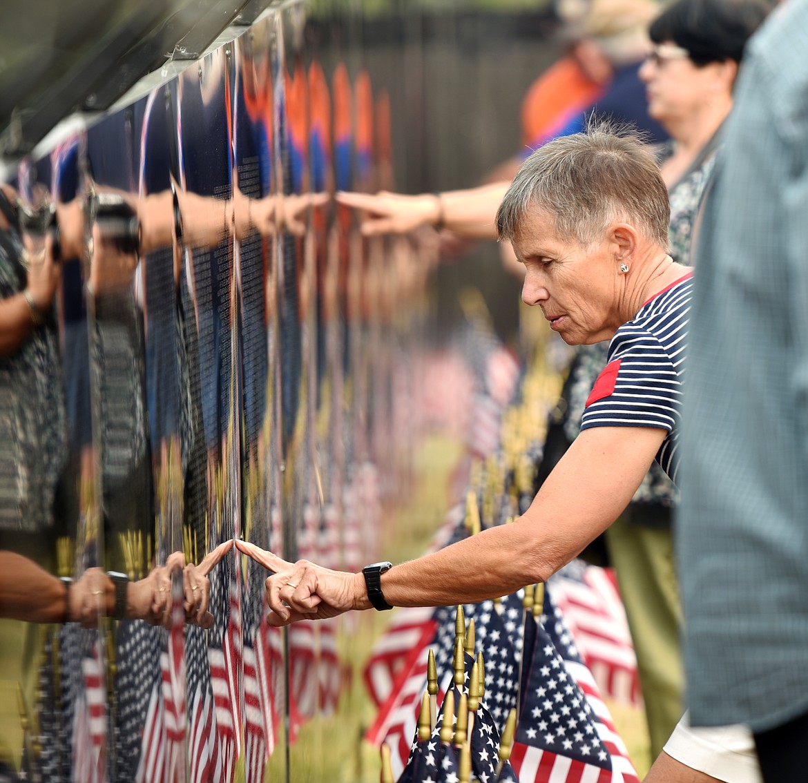 Carolyn Kovacevic points to a name on The Wall that Heals following the opening ceremony on Thursday. Kovacevic is volunteer firefighter with the Ferndale Volunteer Fire Department.