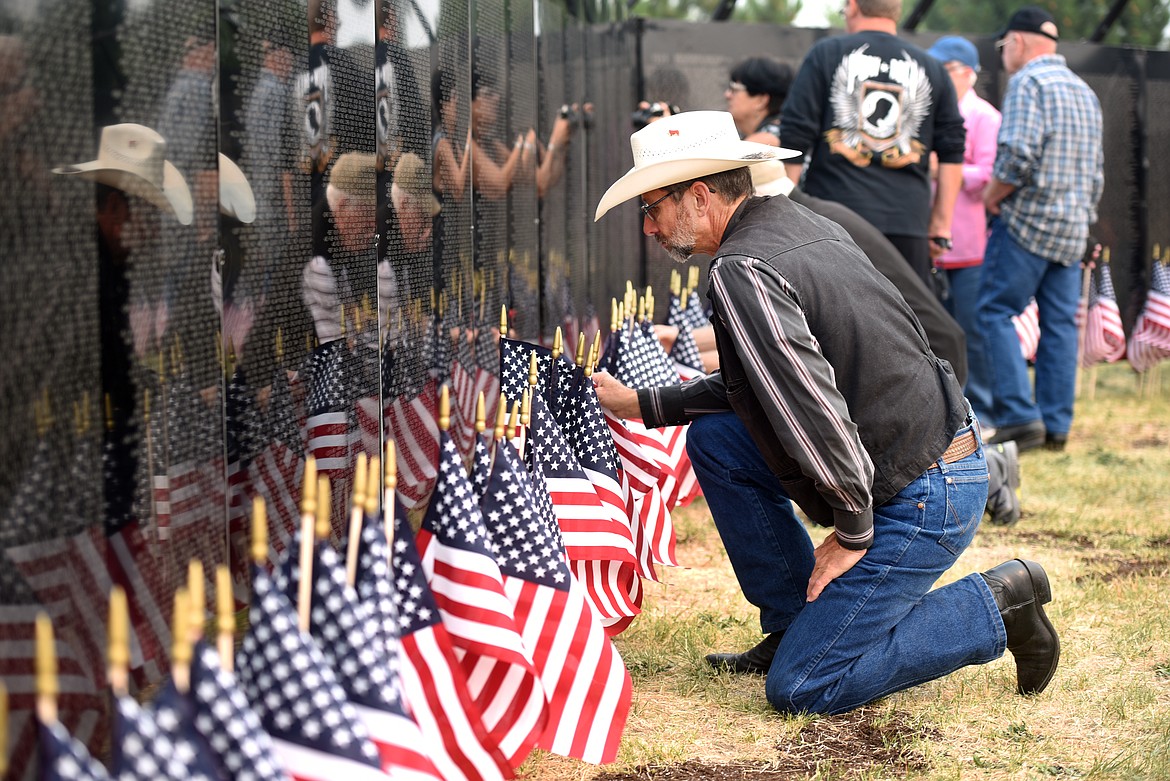 Mark Vrooman of Proctor, Montana, kneels before The Wall that Heals. Vrooman attended the opening ceremony Thursday to pay his respects to Nicholas W. Vrooman, a distant relation and the only person killed while serving in Vietnam with that particular last name. Nicholas W. Vrooman, of Spring Valley, California, was born Feb. 5, 1949. He was serving with the Army and became a casualty of the Vietnam War on May 24, 1970. His name is listed on the Wall at panel 10W, line 93.