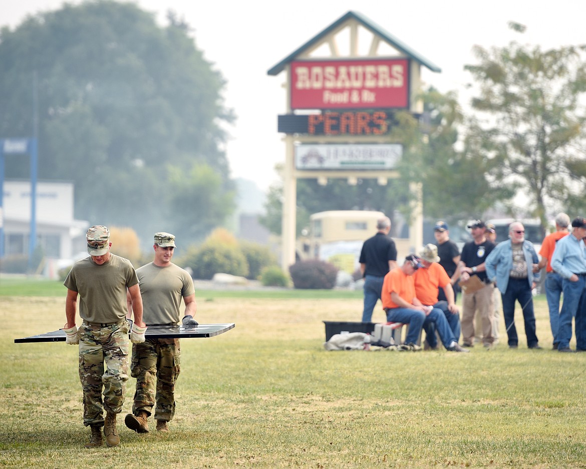 Staff Sgt. Fredrick McCune and Sgt. 1st Class Jonathon Ross carry one of the aluminum panels of The Wall that Heals from where it has been in the truck to the set up site in the field adjacent to Rosauers on Wednesday afternoon, September 6, in Kalispell. McCune and Ross are stationed here in Kalispell while serving as recruiters for the U.S. Army.(Brenda Ahearn/Daily Inter Lake)