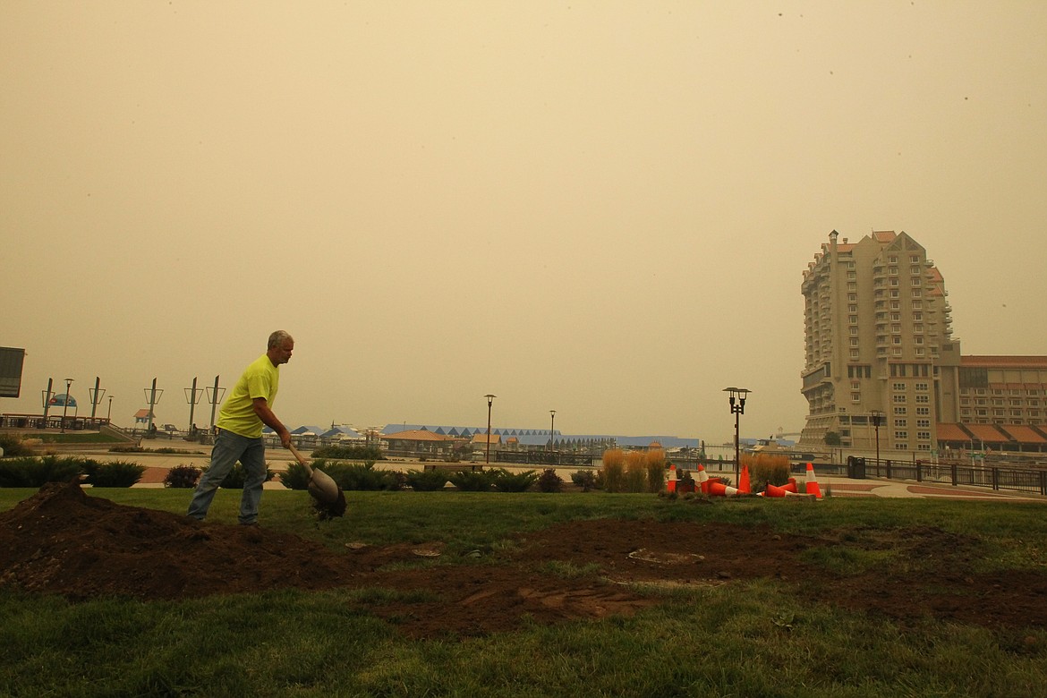 DEVIN HEILMAN/Press
Lead Coeur d'Alene Parks Department worker Larry Walters moves dirt Tuesday in McEuen Park as a heavy haze hangs over The Resort and Lake Coeur d'Alene. The Idaho Department of Environmental Quality deemed North Idaho's air quality Tuesday as &#147;unhealthy&#148; to &#147;hazardous&#148; and advised residents to limit time outdoors.