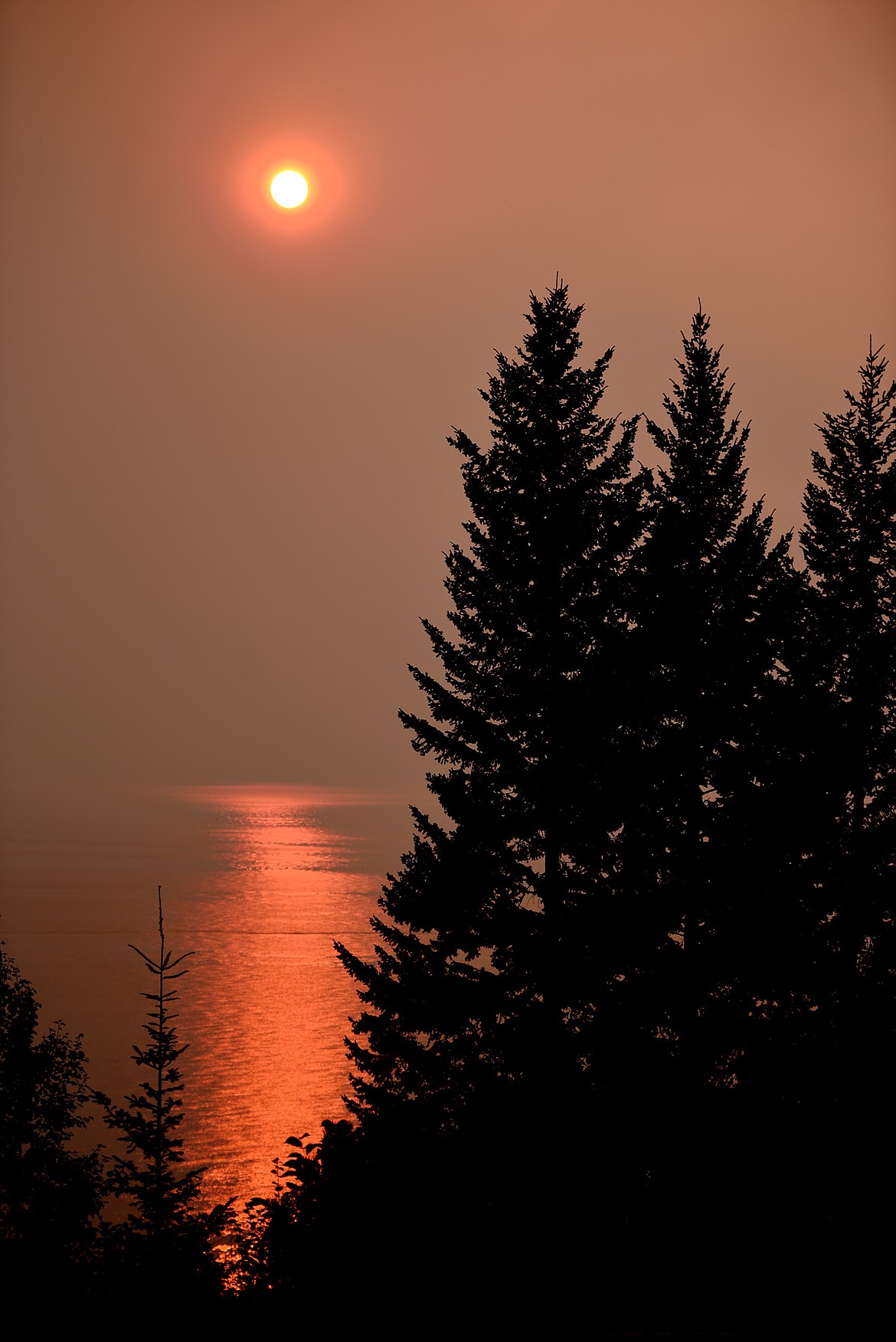 A smoke-filled sunset gives a deep red cast to the reflections on Flathead Lake on Sunday, September 3 from Woods Bay.(Brenda Ahearn/Daily Inter Lake)