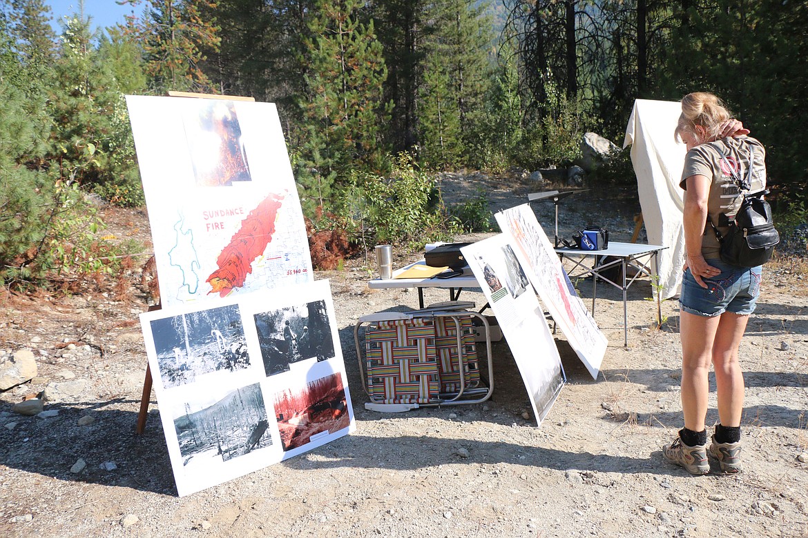 (Photo by CAROLINE LOBSINGER)An individual looks over a map and old photos of the Sundance Fire on Saturday during a 50th anniversary commemoration of the massive fire. The fire burned more than 56,000 acres in August and September of 1967.