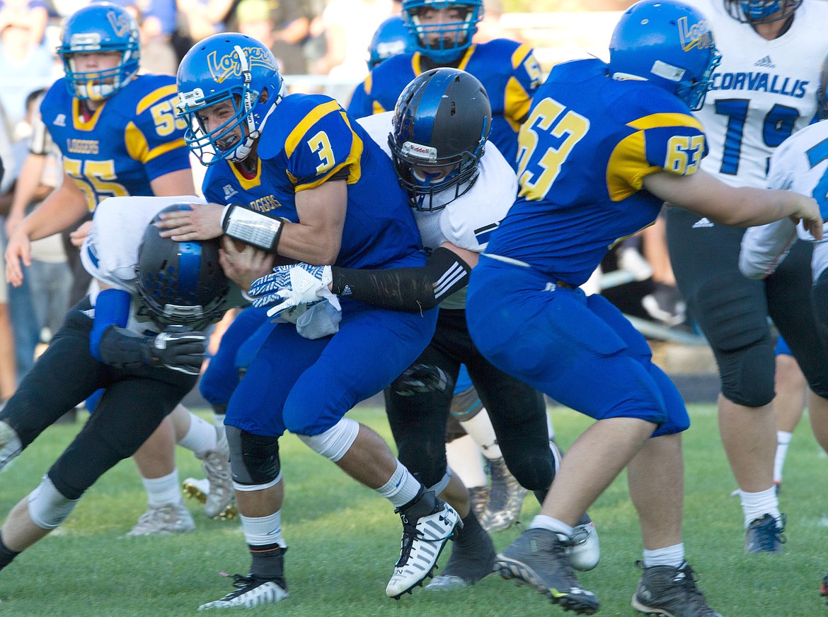 Libby Quarterback Brian Peck gets taken down by Corvallis defenders Friday night in Libby.