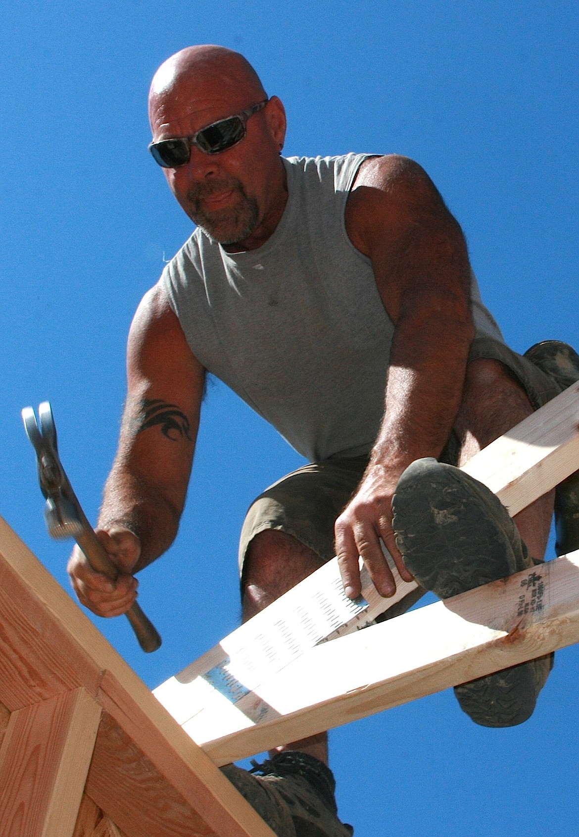 BRIAN WALKER/Press
Mike Garr, who works for a subcontractor of Daum Construction, works on framing a garage on a new home in Spirit Lake on Friday.