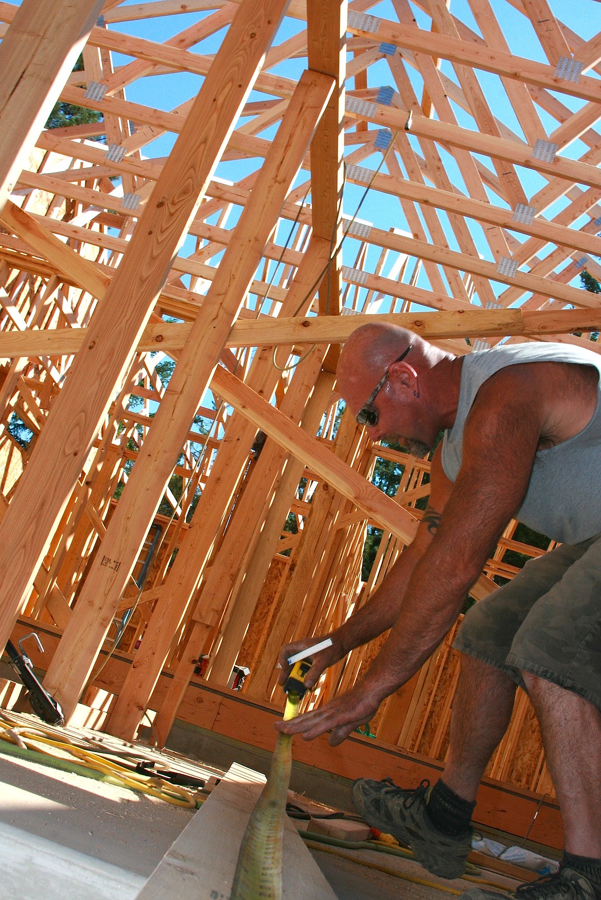 BRIAN WALKER/Press
Mike Garr, who works for a subcontractor of Daum Construction, works on the frame of a Spirit Lake home Friday. The city has implemented a moratorium on new building permits and is exploring options on how to expand its wastewater capacity.