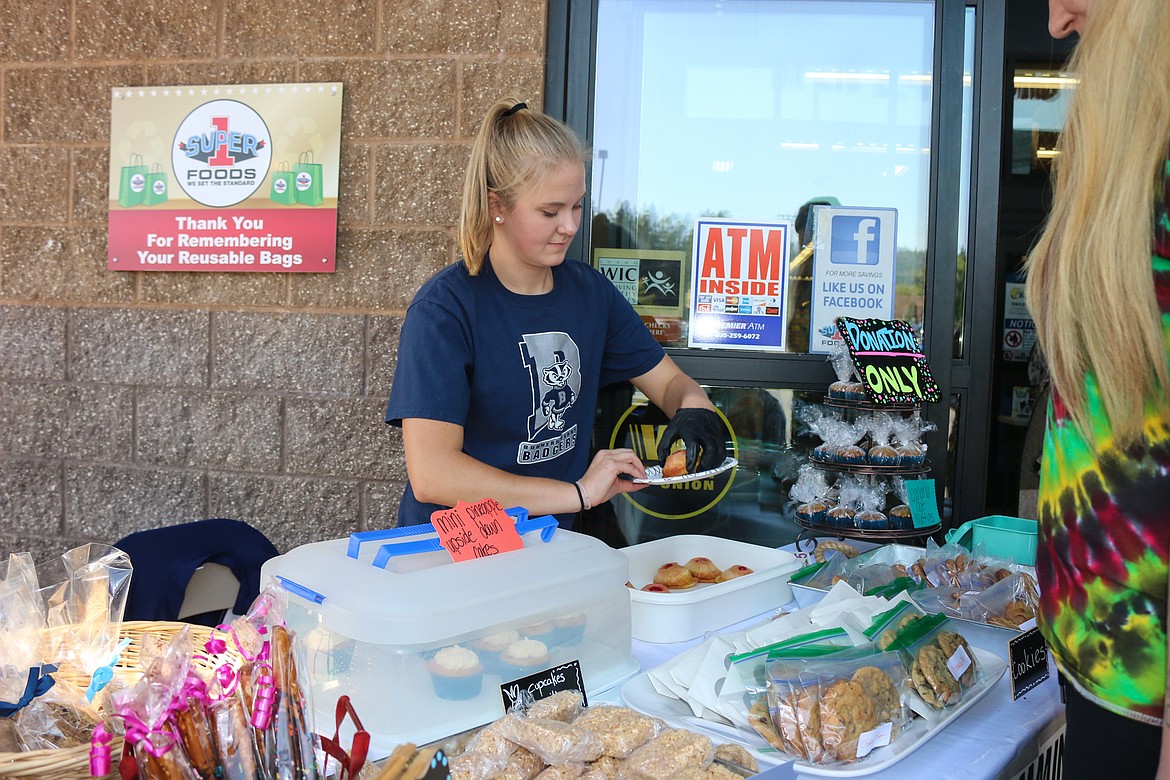 Julia Cummings prepares a pineapple upside down cake for a guest during her bake sale fundraiser for the Bonners Ferry High School swim team. All items were available for donation only.