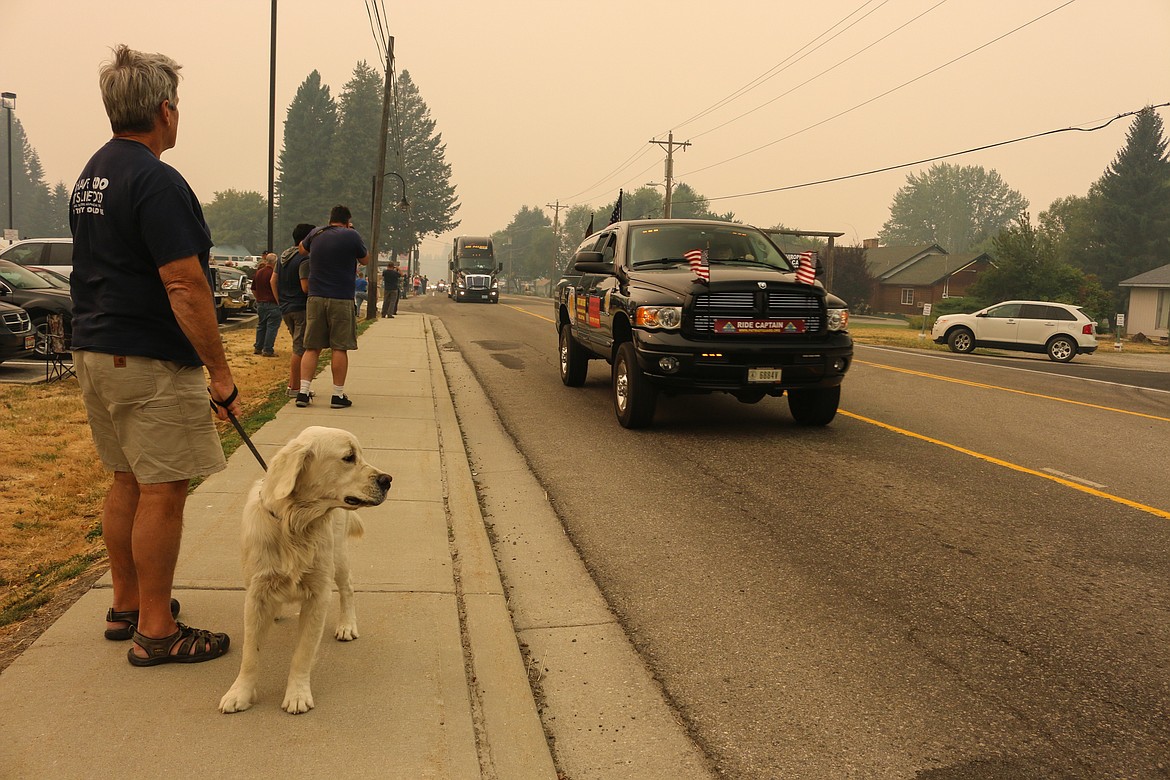 Photo by Mandi Bateman
Chris Wheeler and his Golden Retriever, Comet, watch The Wall That Heals and its entourage.