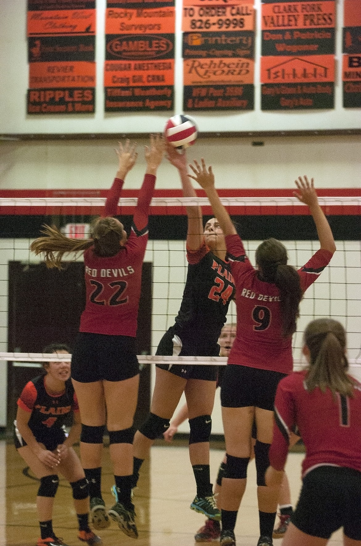 Plains senior Kara Altmiller (24) tips the ball past Noxon&#146;s Cory Brodmerkle (9) and Anna Kaiser (22). The Trotters swept the Lady Red Devils in three games. (Jeremy Weber/Clark Fork Valley Press)