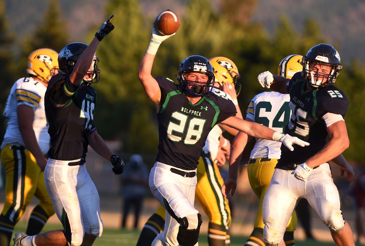 Glacier defensive back Garrett Frost (28) celebrates with teammates Ethan Baines (45) and Jackson Pepe (25) after picking off the ball near the goal line near the end of the second quarter against C.M. Russell in Columbia Falls on Friday. (Aaric Bryan/Daily Inter Lake)