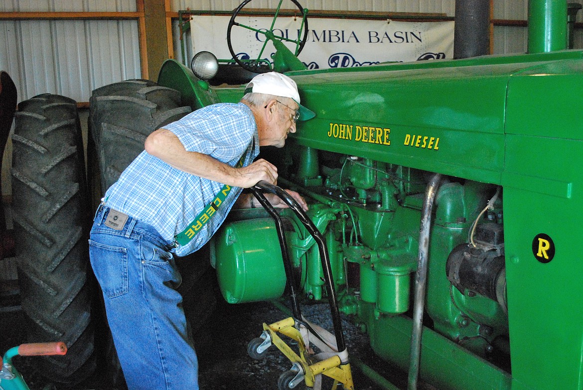 Bob Kirkpatrick/The Sun Tribune - Jim looks for the model number on his 52&#146; Canadian John Deere diesel. It was the 639th tractor off the line.