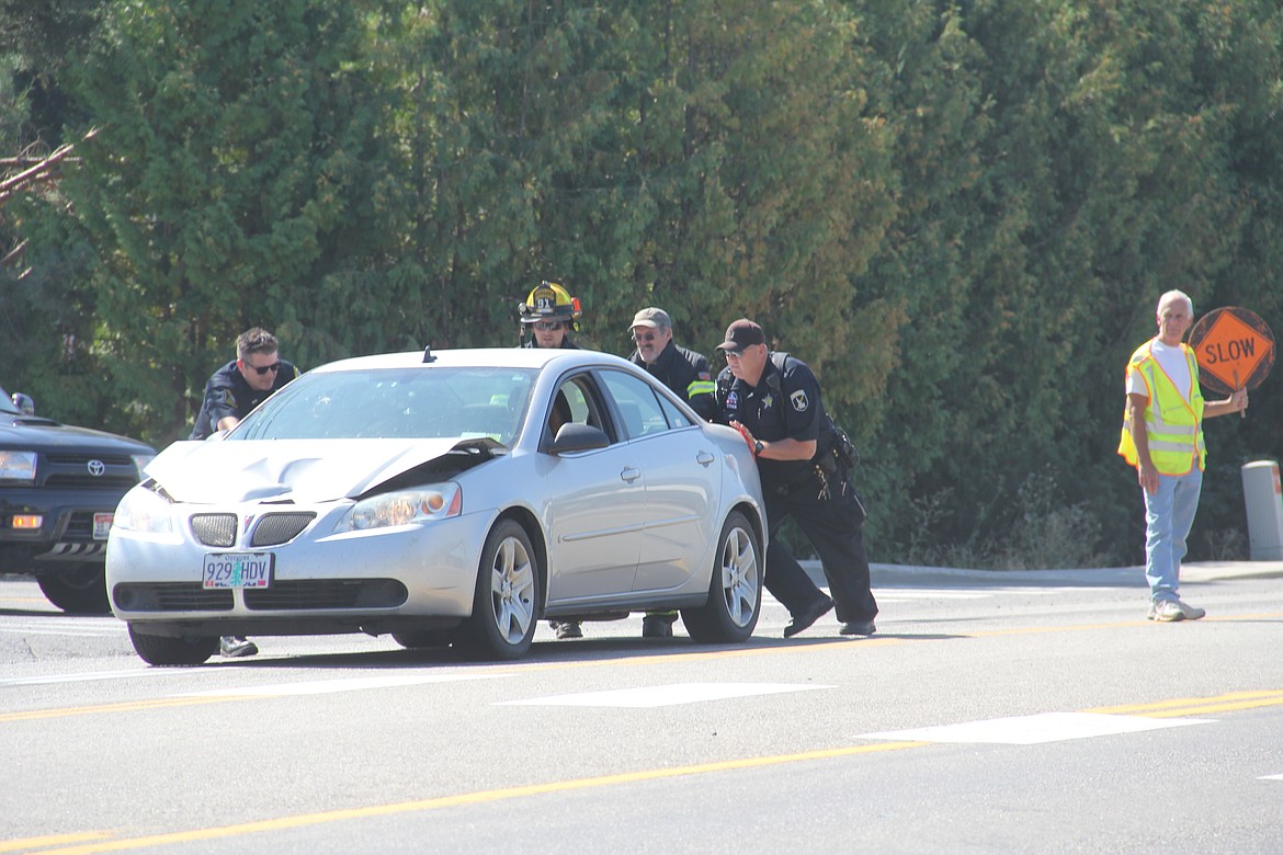 Photo by Tanna Yeoumans
Bonners Ferry Police Lt. Christian Fry, along with help from the Bonners Ferry City Fire Department and Idaho State Police, help to remove a vehicle from Highway 95 after an accident occurred in front of Pizza Factory on the morning of Sept. 1.