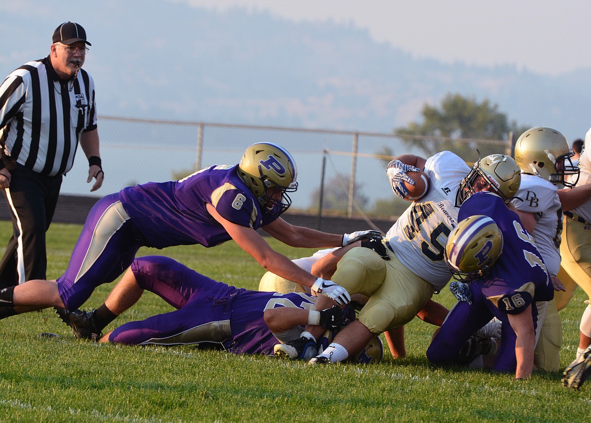 POLSON PIRATE Haden Smith, Kyle Druyvestein, and Parker Toth attempt to tackle a Dillon ball carrier in the first half of the Dillon game Friday night at Polson High School. (Jason Blasco/Lake County Leader)