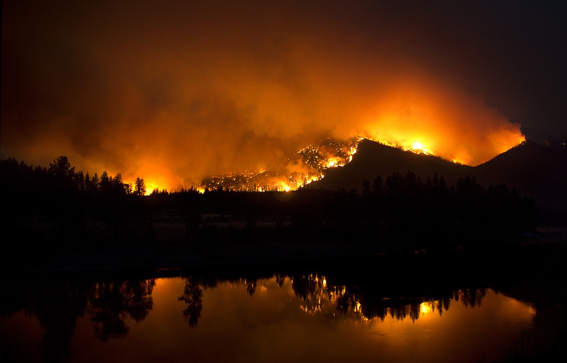The Sheep Gap Fire burns along the Clark Fork River west of Plains Saturday. Sections of River Road West have been closed and evacuations in the area began Saturday afternoon. (Jeremy Weber/Clark Fork Valley Press)