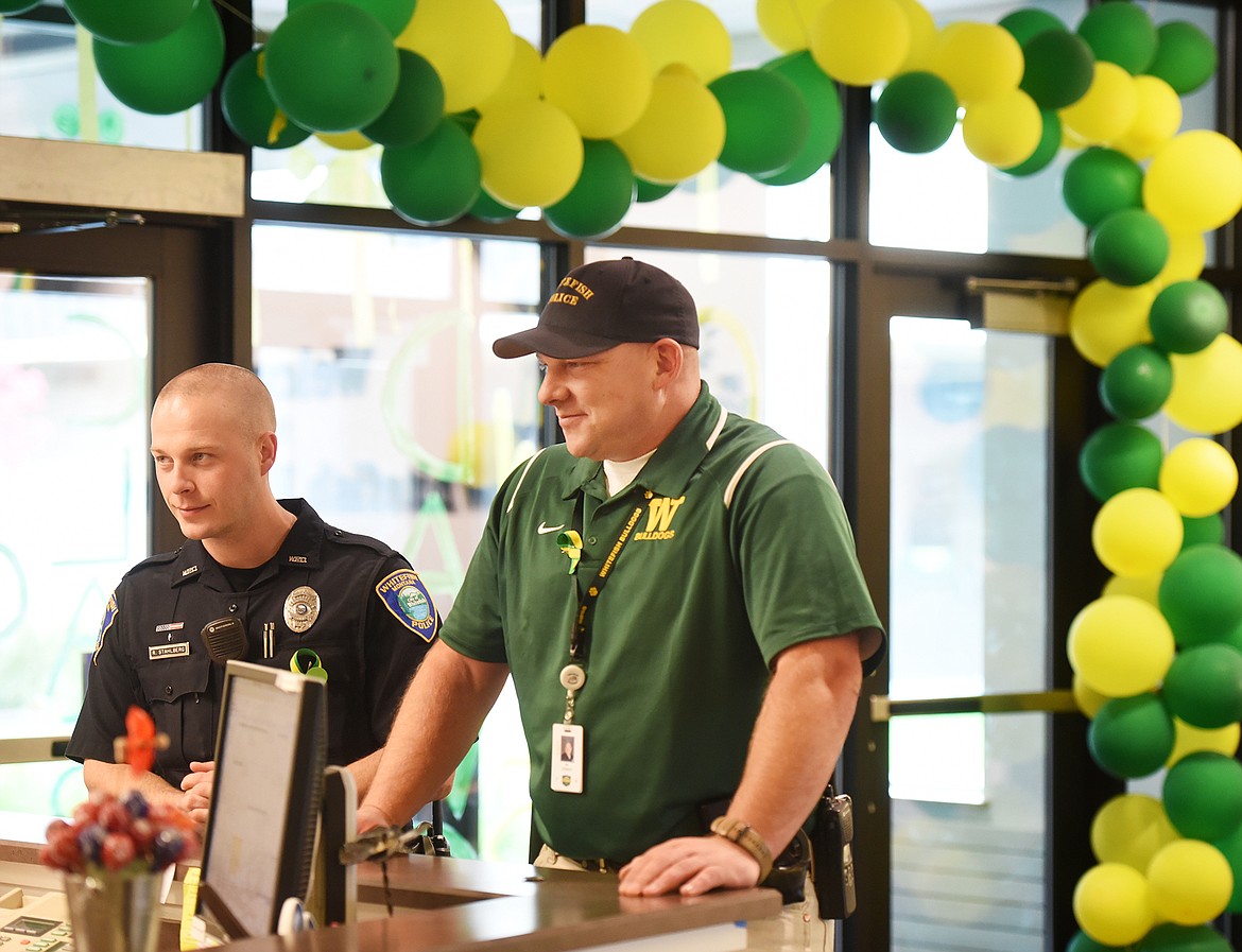 School Resource Officer Ryan Zebro, right, and Patrol Officer Reece Stahlberg talk with the staff at the front office at Whitefish High School on Tuesday, September 19. In the background are home coming directions. Homecoming had been scheduled for September 15, but had to be put on hold as the law enforcement community investigated the threat that caused schools across the Flathead to be closed.(Brenda Ahearn/Daily Inter Lake)