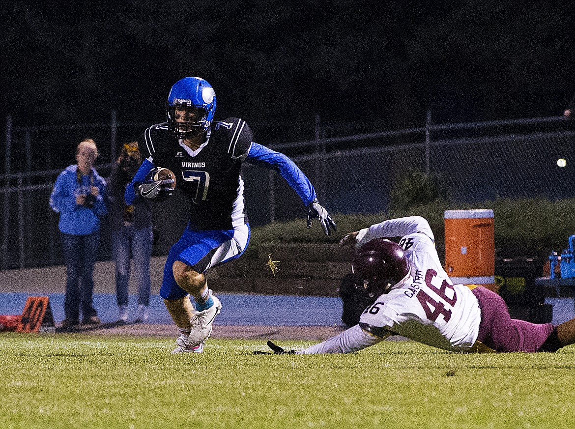 LOREN BENOIT/PressCoeur d'Alene wide receiver Sam Matheson escapes Payton Castro's tackle during Friday's game against Moses Lake High School.