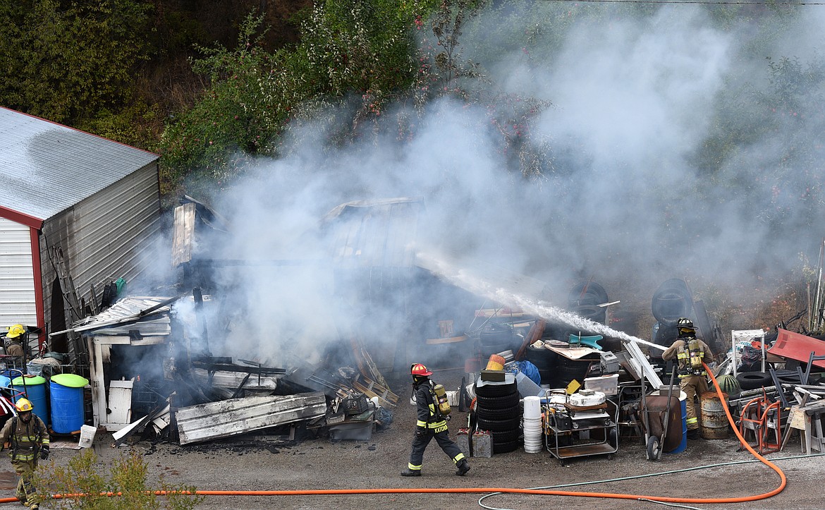 Firefighters work to extinguish a shed that caught fire on Happy Hollow Road in Somers on Tuesday. (Aaric Bryan/Daily Inter Lake)