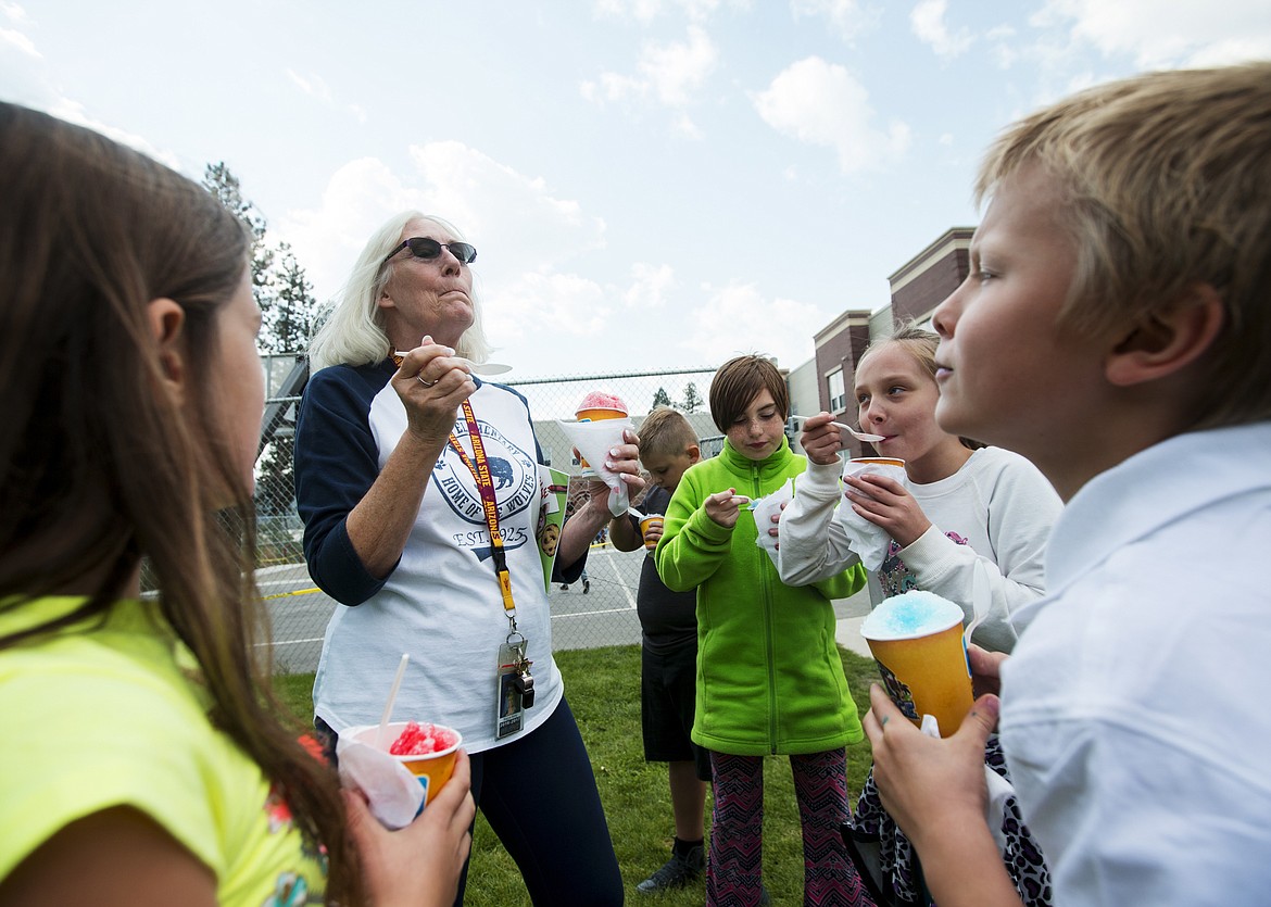 LOREN BENOIT/PressFrom left, Winton Elementary School students Samantha Taub, Dezirai Teeter, Addie Knob and Thomas Moore watch eager as teacher Maggie Kemp tries her watermelon shaved ice during school on Friday.