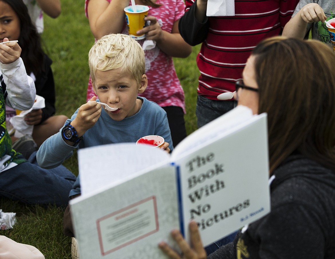 LOREN BENOIT/PressWinton first-grader Josiah Morris listens and eats his shaved ice as Mrs. Teal reads &quot;The Book With No Pictures&quot; Friday morning at school.