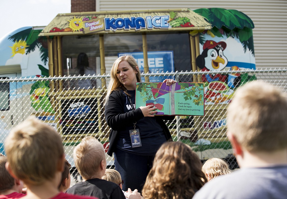 LOREN BENOIT/PressWinton Elementary School teacher Carrie Waddell reads a book to her class as her students eat shaved ice Friday morning at school.