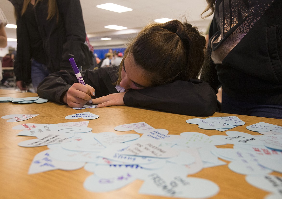 LOREN BENOIT/PressCoeur d'Alene High School student Taylor Deming writes a kind note for Freeman High School students Thursday morning after one student was killed inside Freeman High School near Spokane, Washington.