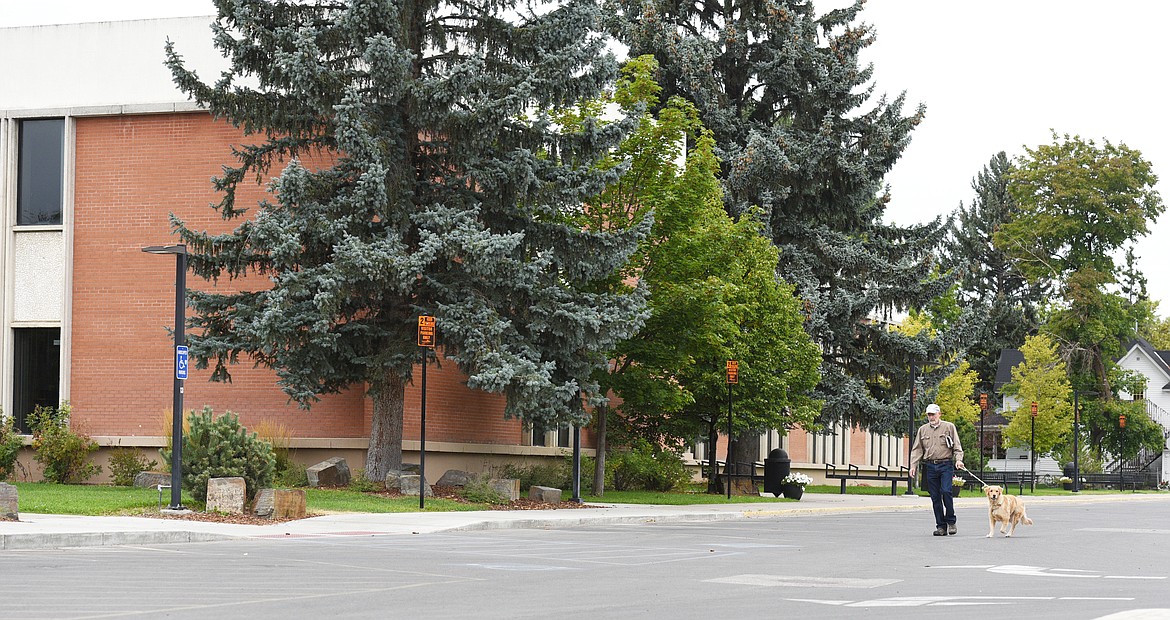 Gary Bushaw walks his dog Piper through the empty Flathead Highschool parking lot on Thursday. (Aaric Bryan/Daily Inter Lake)