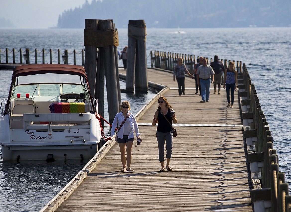 LOREN BENOIT/PressCoeur d'Alene residents Kristy Baca, left, and Jessica Cobb walk on The Coeur d'Alene Resort Boardwalk Tuesday afternoon.