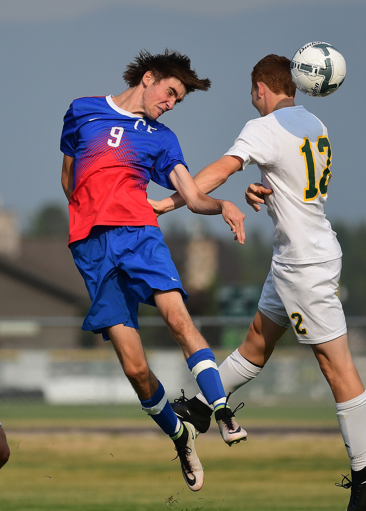 Wildcat Tristan Grien (9) heads the ball into the goal against Whitefish defender Tait Workman Tuesday. The Bulldogs won, however, 3-2. (Chris Peterson photo/Hungry Horse News)