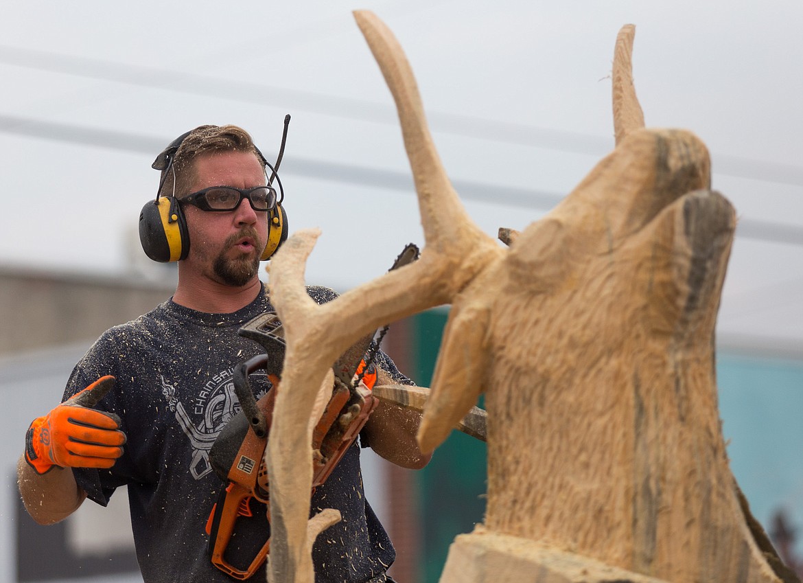Jacob Lucas gives his right hand a rest while competing Saturday in the Kootenai Country Montana Chainsaw Carving Championship in Libby. See more photos on page B1. (John Blodgett/The Western News)