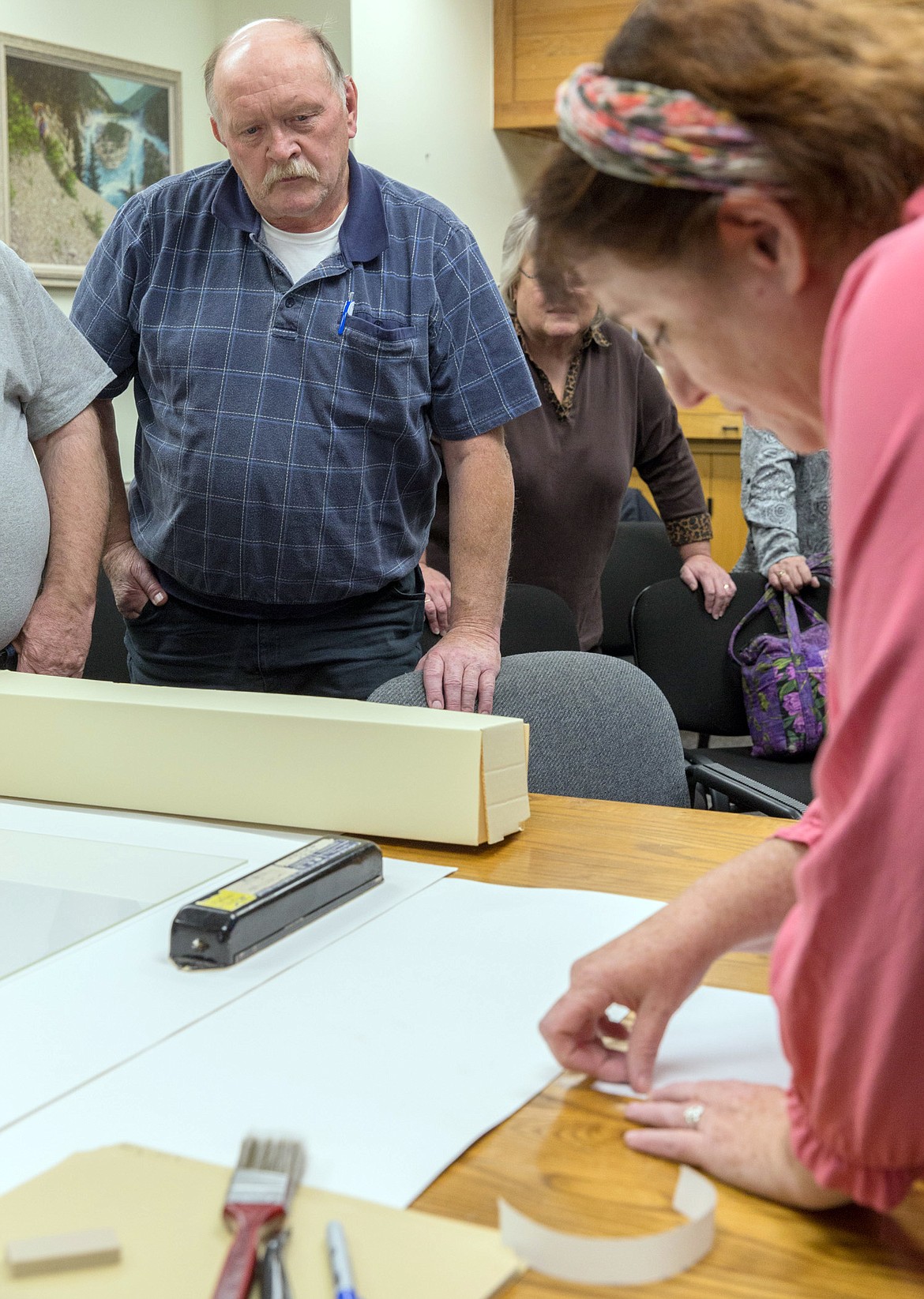 Robert Stickney watches Jodie Foley of the Montana Historical Society demonstrate archiving methods at the Lincoln County Courthouse on Friday. Stickney and other volunteers were attending a day-long training in advance of "Archives Blitz," a maps-preserving, open-to-the-public event that will take place 9 a.m. to 2 p.m. Oct. 9 to Oct. 13 at the Ponderosa Room at 952 E. Spruce St. near City Hall. (John Blodgett/The Western News)