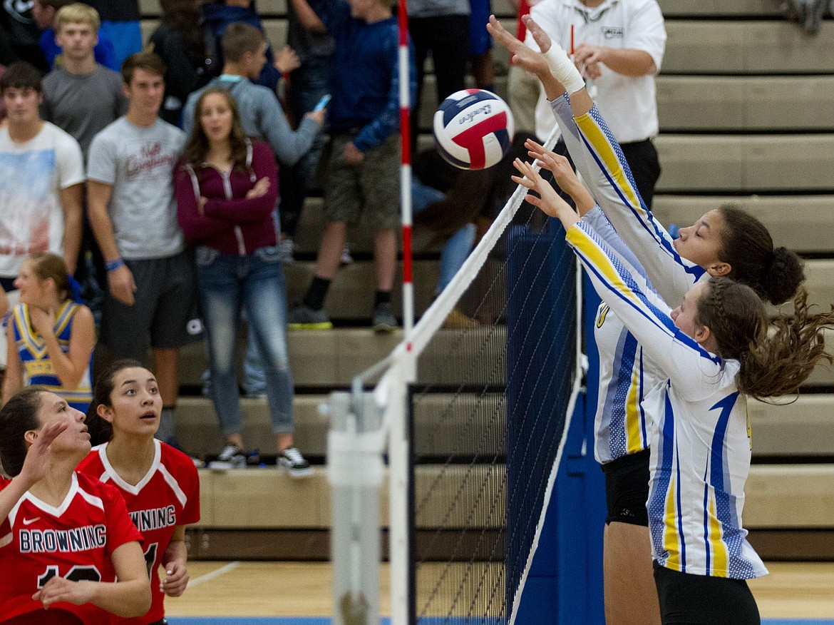 Jayden Winslow, right foreground, and Mehki Sykes, right background, go for a block against Browning Saturday in Libby. (John Blodgett/The Western News)