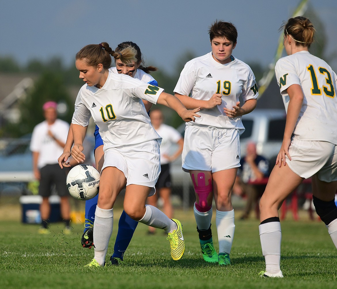 Ali Hirsch, Abby Lowry and Grace Scrafford fight off a Columbia Falls player last Tuesday at Smith Fields. (Chris Peterson/Hungry Horse News)