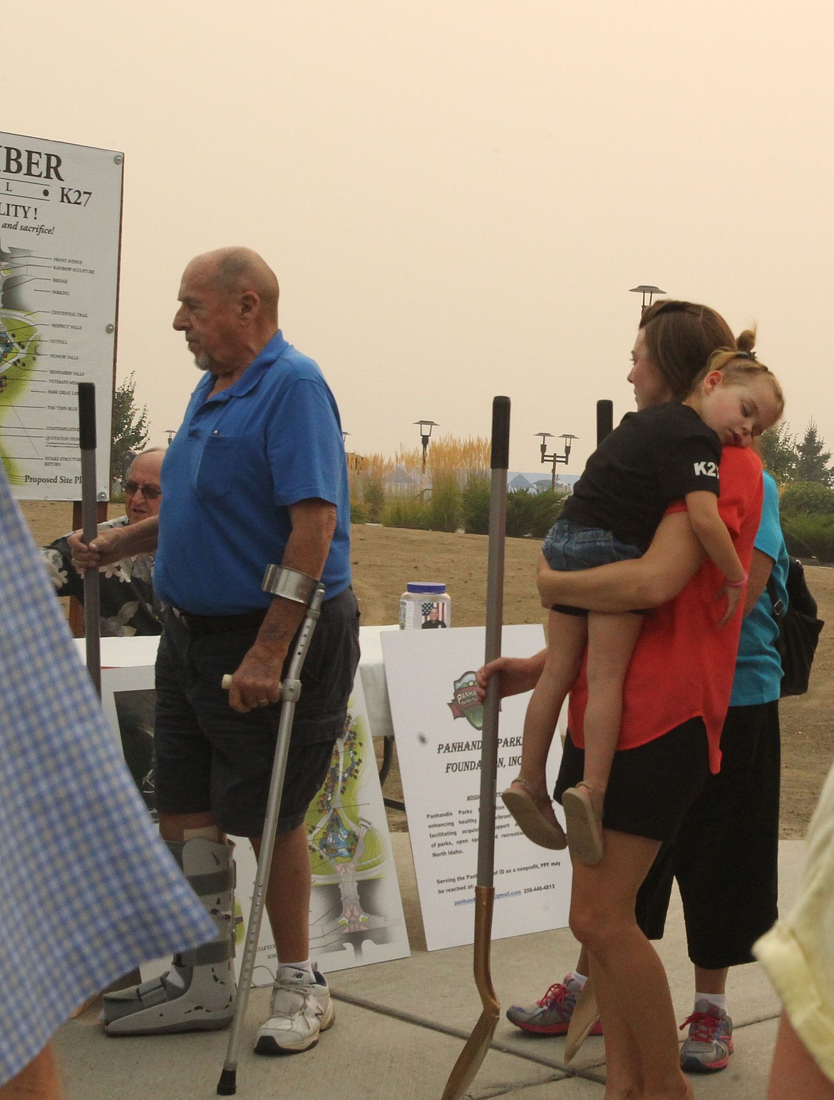 DEVIN HEILMAN/Press
Sgt. Greg Moore's wife, Lindy, holds sleepy daughter Gemma, 3, as they follow Moore's father, Fred, to the site of the future K27 Memorial during the groundbreaking Thursday evening in McEuen Park.