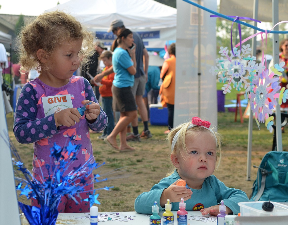 Peta-Jean Lamb, 2, and Francesca Lamb, 3, decorate snowflakes Saturday during the Whitefish Community Foundation Nonprofit Fair in Depot Park. (Heidi Desch/Whitefish Pilot)