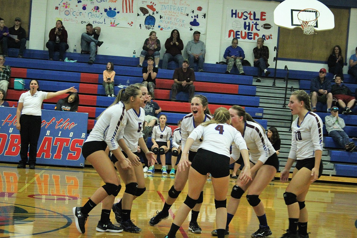 The Clark Fork Mountain Lady Cats celebrate a successful return during their homecoming game against Noxon last Thursday in Superior where they lost 3 of 4 matches. (Photo by Frankie Kelly)