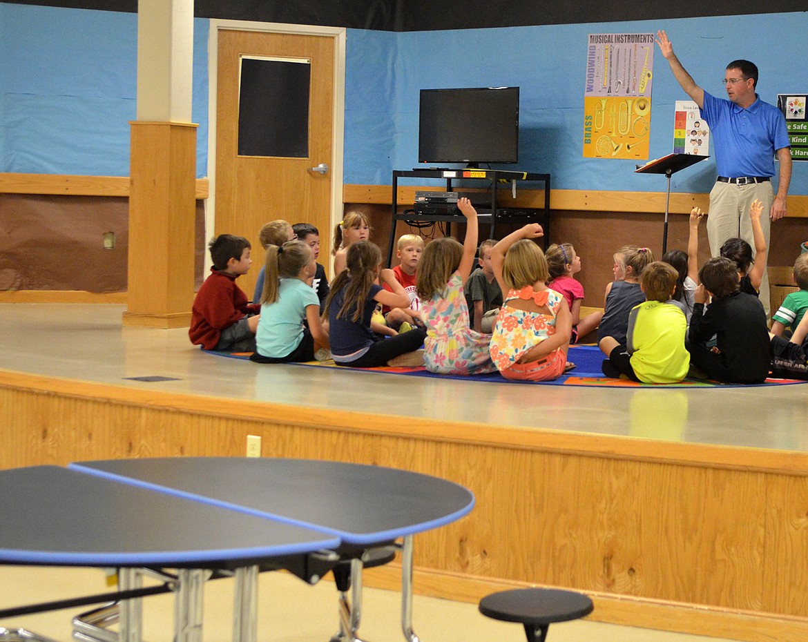 Muldown music teacher Paul Rossi works with students on a recent morning on the stage inside the school&#146;s multi-purpose room, where lunch is also served. There is no dedicated classroom for the music program. (Heidi Desch/Whitefish Pilot)