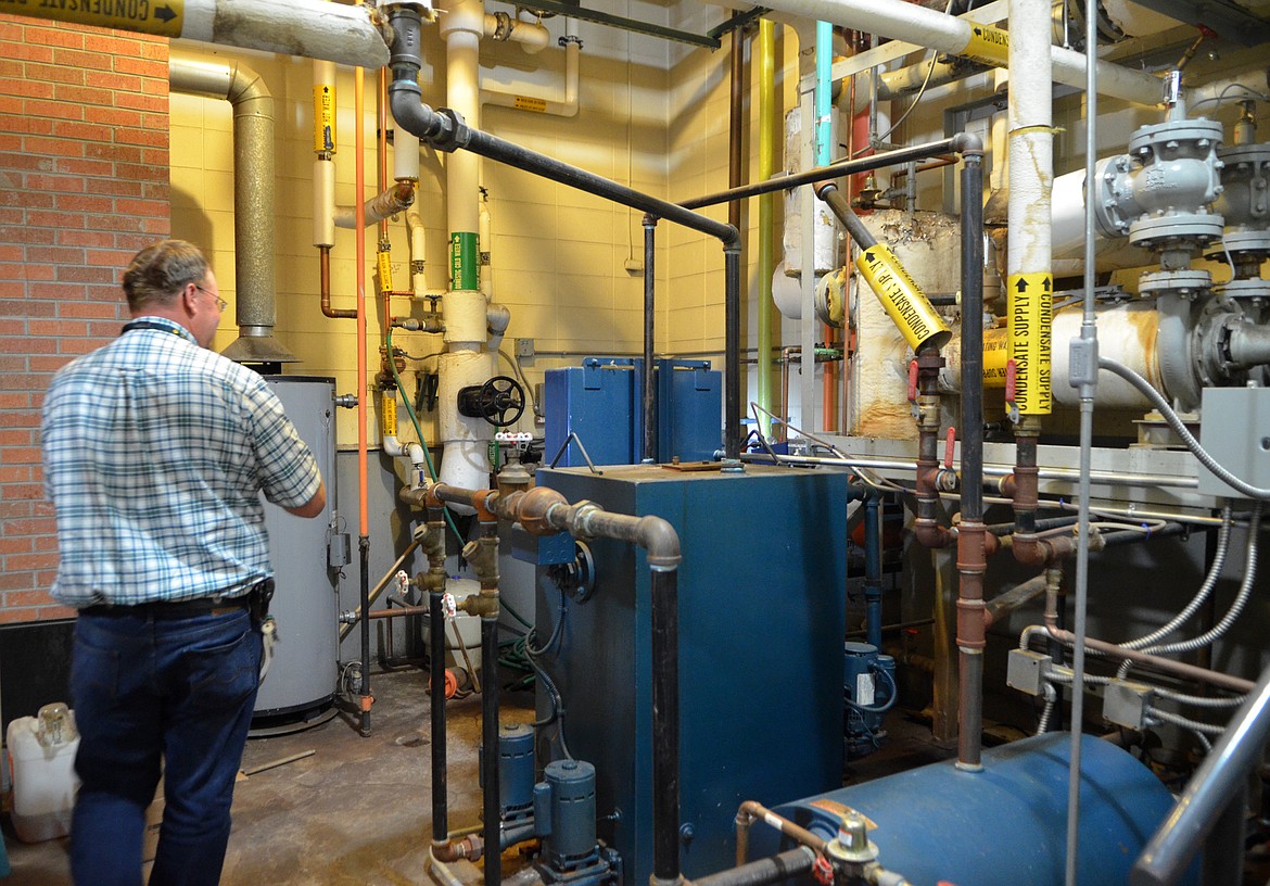 Whitefish Schools Maintenance Director Chad Smith looks over the boilers inside Muldown Elementary School. The 50-year-old heating system is failing, according to the school district, and the building has a number of issues including roof trusses that cannot adequately support snow loads and many parts of the building lack insulation and rooms that have drastic temperature fluctuations. (Heidi Desch/Whitefish Pilot)