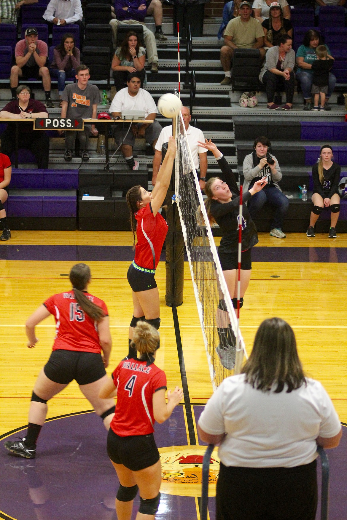 Photos by Chanse Watson/ (From right) Mullan junior Lindsey Foster tips the ball over the net while Wallace senior Kayla Slater attempts to block it. Maggie Howard and Halei Ungerbuehler stand ready.
