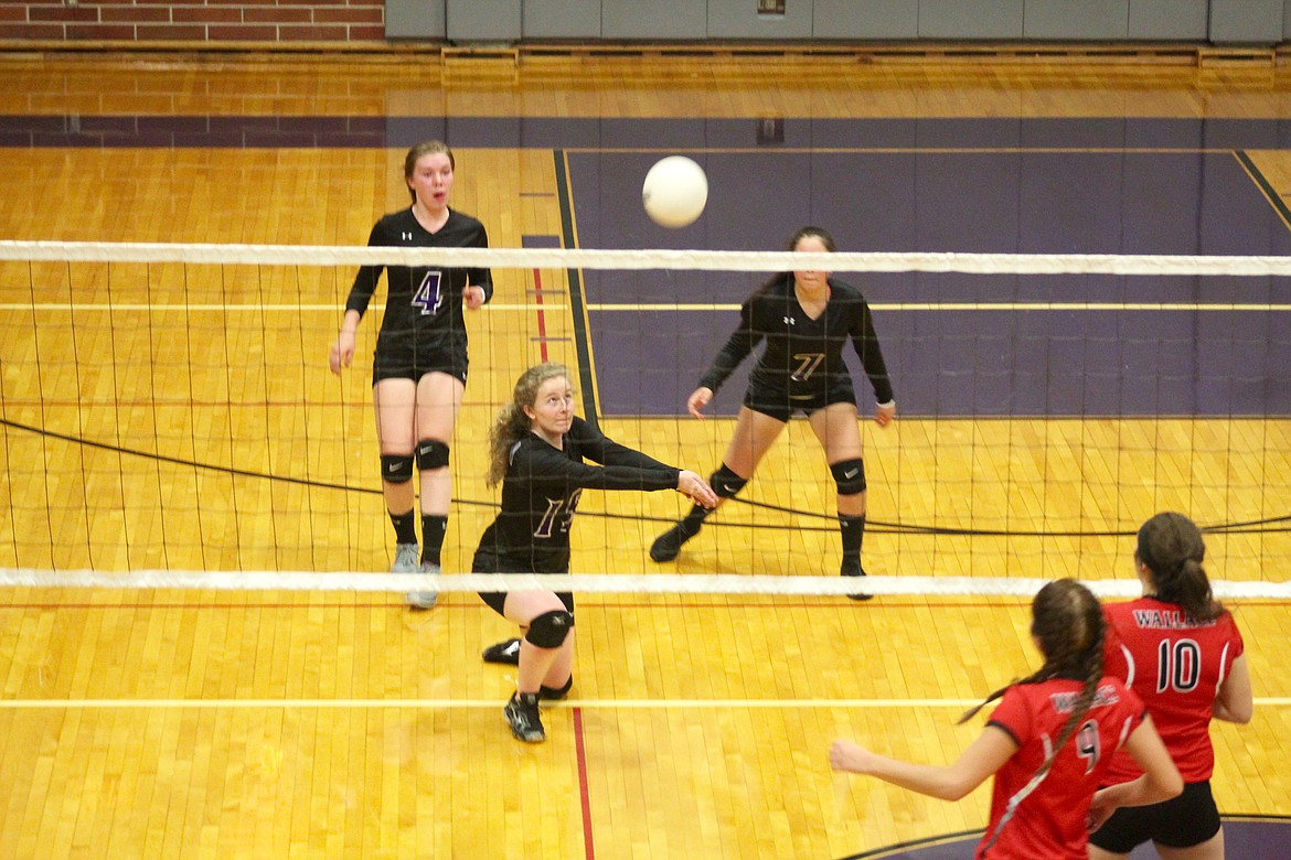 Mullan freshman Emily Dykes hits the ball while juniors Lindsey Foster and Sydnie Cote support.