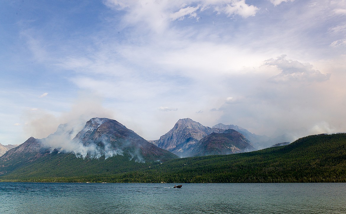 A boater glides by the Sprague Fire Sunday afternoon.