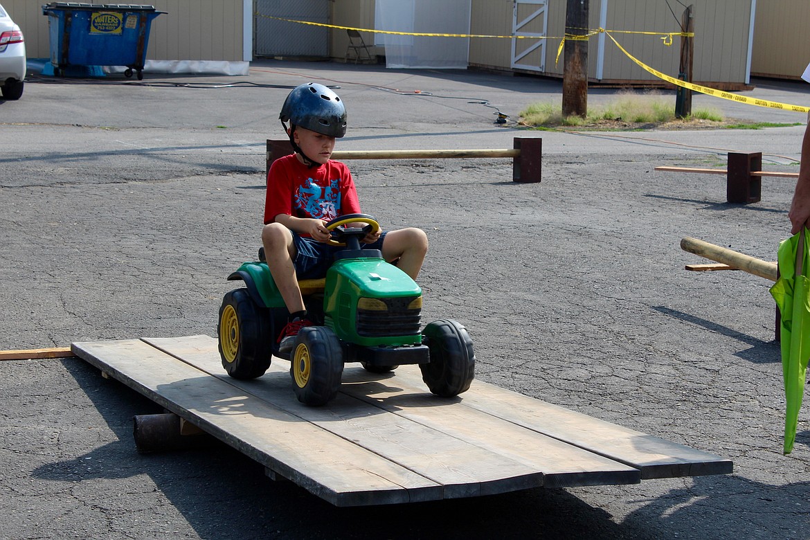 Going up and coming down! This youngster takes his John Deer up the wooden plank.