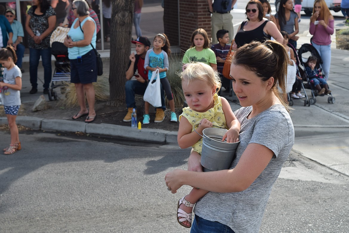 Charles H. Featherstone/Columbia Basin Herald
A young woman throws candy to kids during the Farmer Consumer Awareness Day Parade in Quincy on Saturday.
